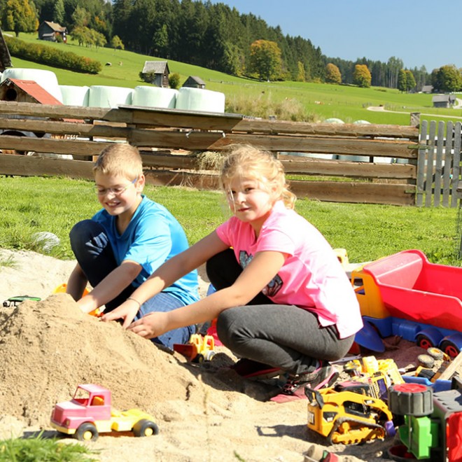 Kinder spielen im Sandkasten auf unserem Spielplatz